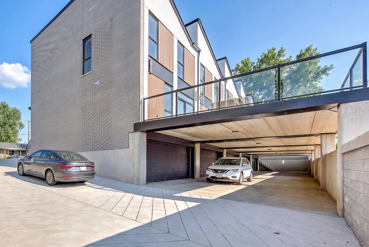 Cars parked on the ramp behind the Park Townhomes, beneath the raised patio decks.